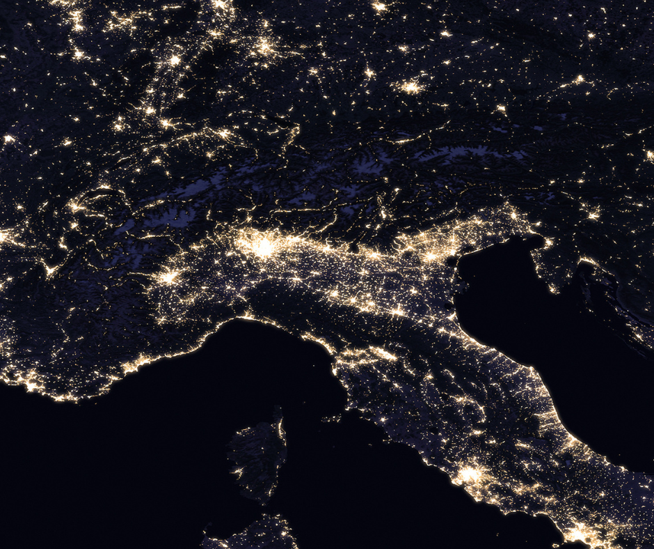 Northern Italy at night showing bright arc and dark mountains